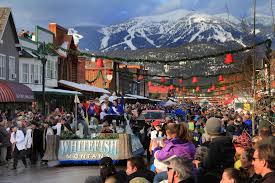 Whitefish Montana Winter Carnival street scene with festive themed decorations and Whitefish Mountain Resort in the background.