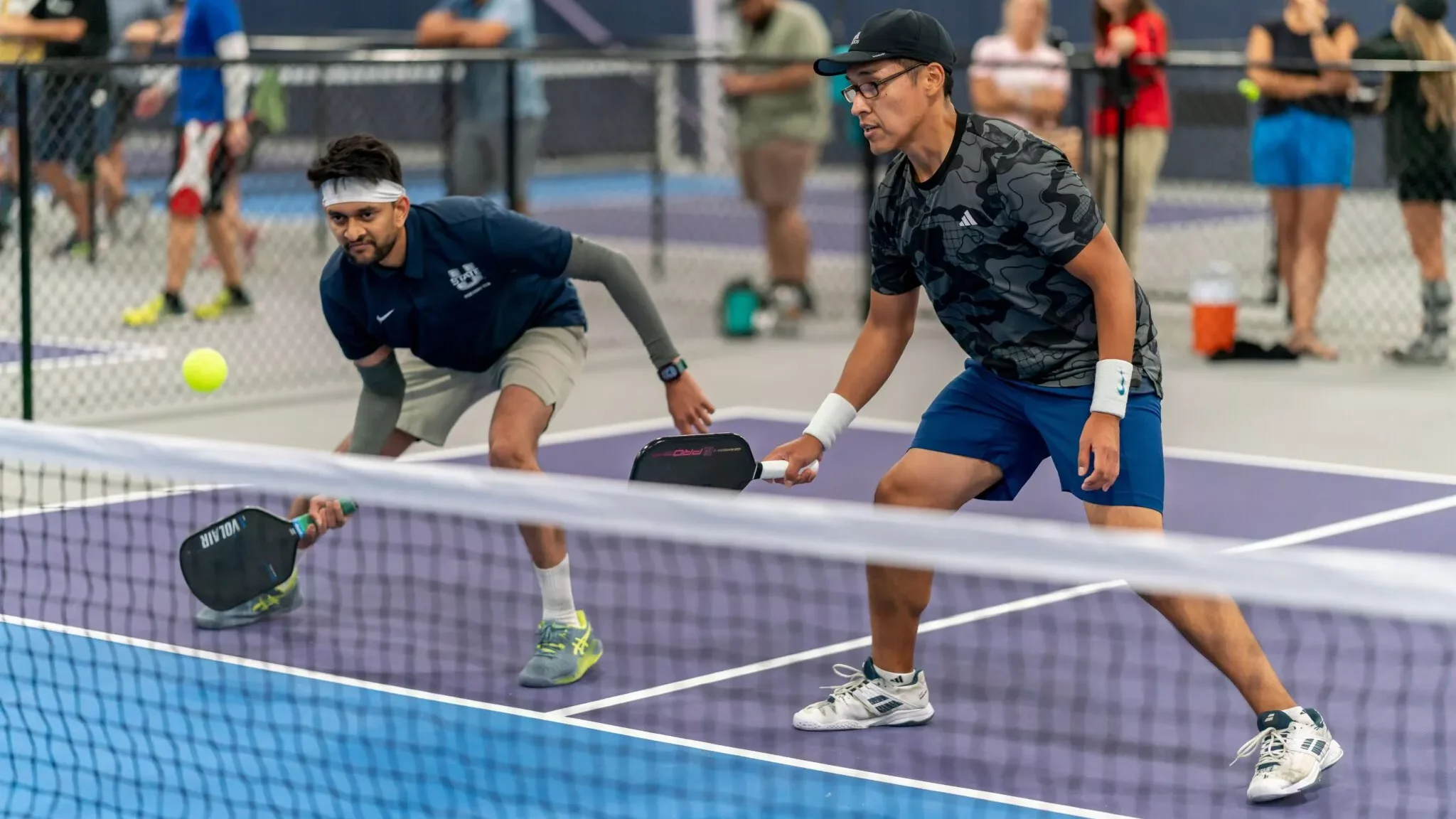 Men playing pickleball at the net