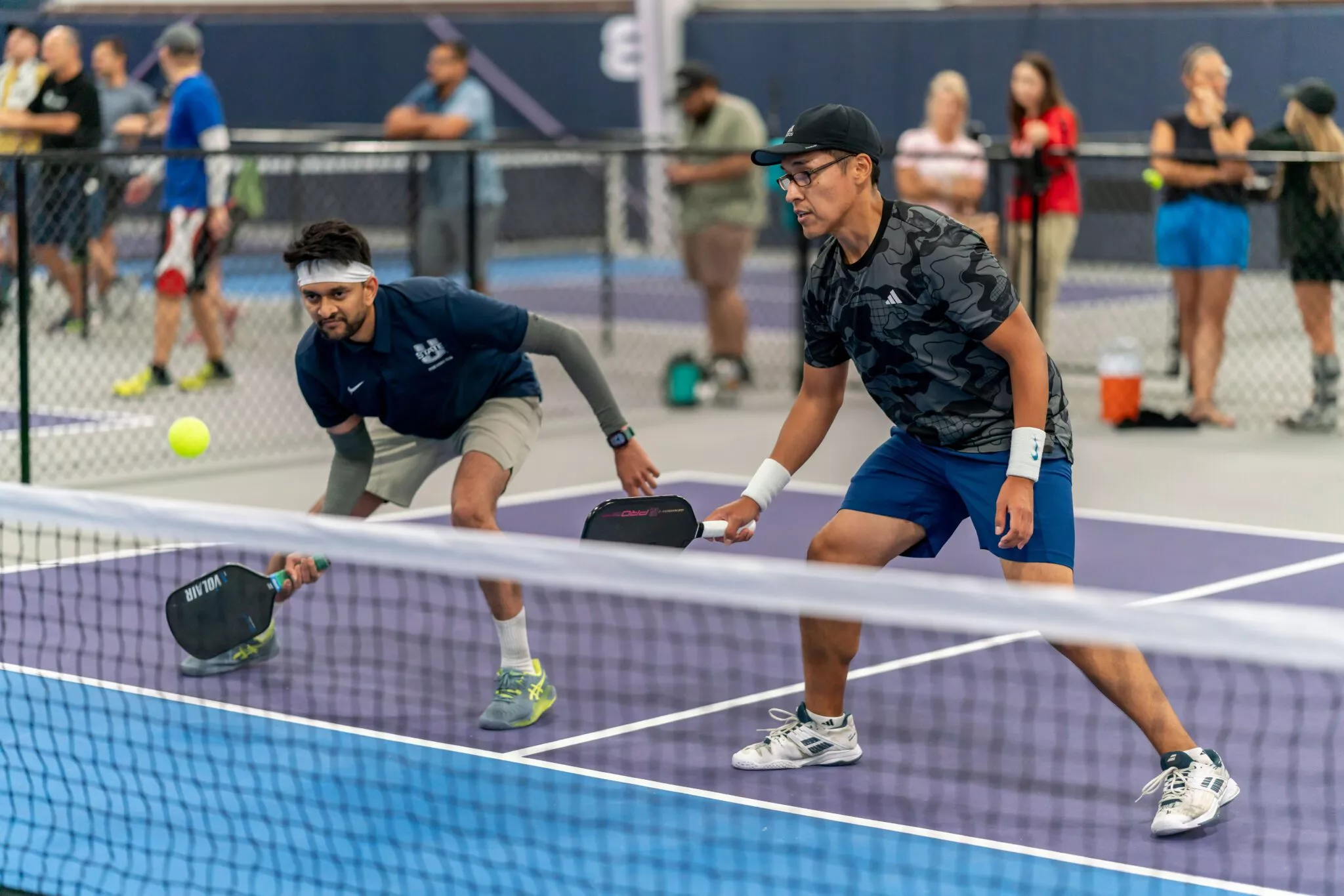 Men playing pickleball at the net