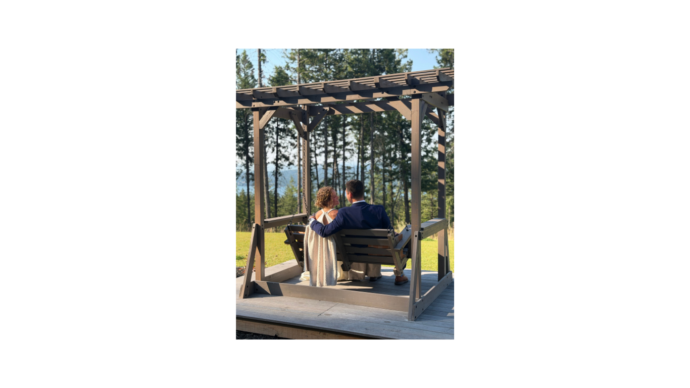 Bride and groom overlooking Whitefish Lake in a craftsman swing.